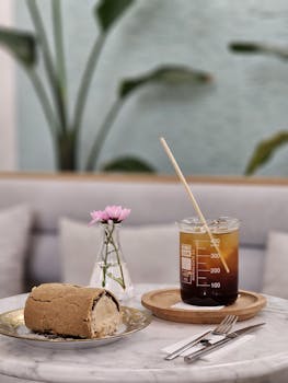 A sleek marble table with coffee and cake elegantly presented in a modern cafe setting.