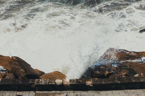 Free Waves crashing on rocky coast, showcasing power of nature and rugged beauty of the shoreline. Stock Photo