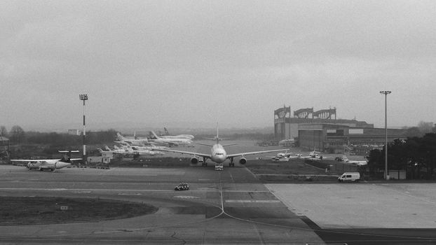 Monochrome view of Belgrade Airport with several aircraft, capturing urban aviation activity.