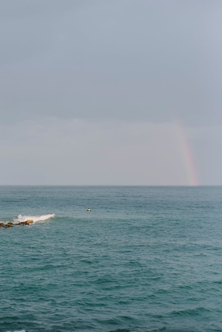 Blue Sea And Rainbow Behind