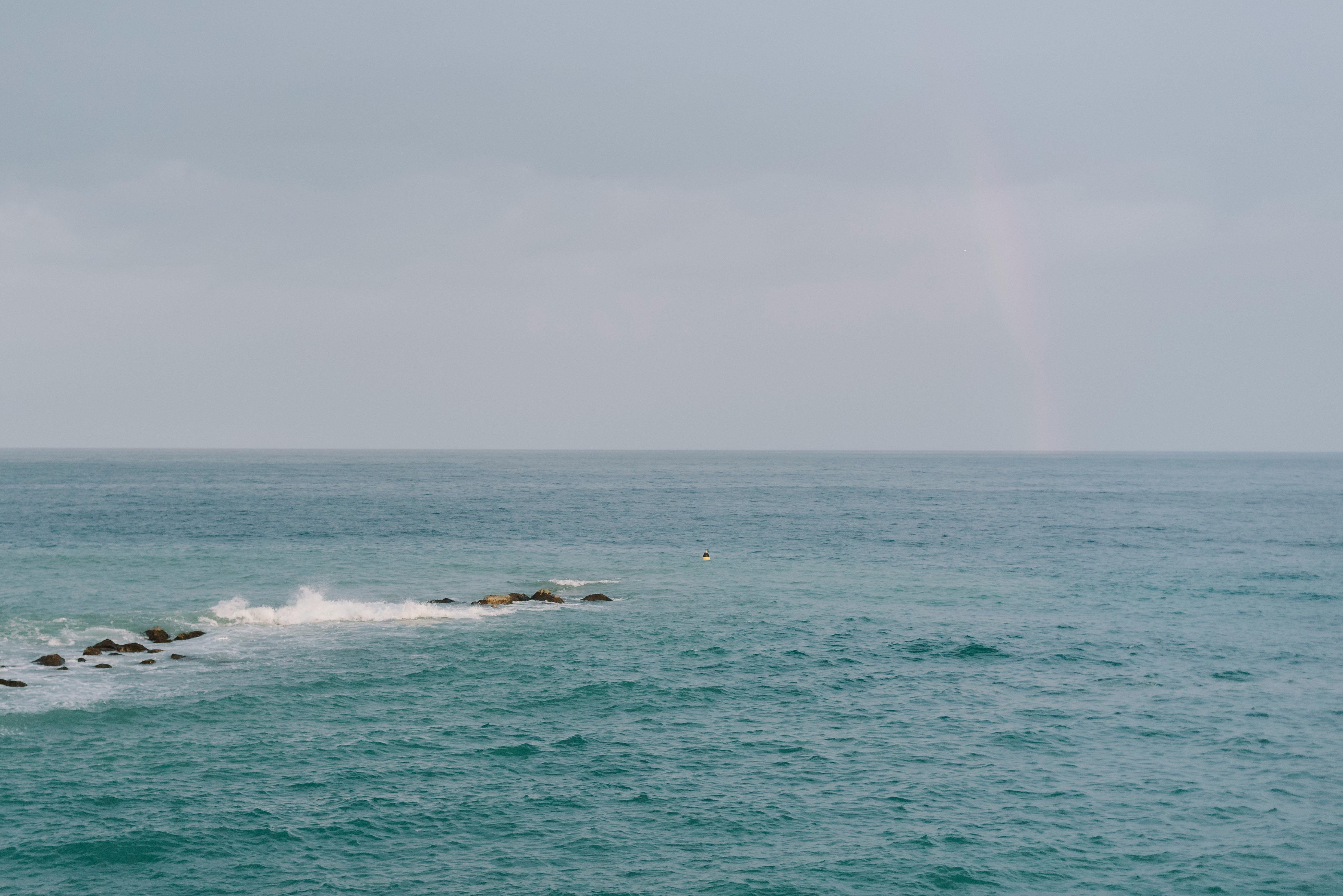 Calm Sea Coast and Rainbow behind