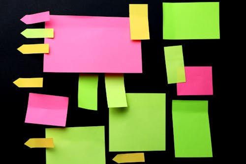 Sticky Notes in Various Colors and Shapes on a Black Background