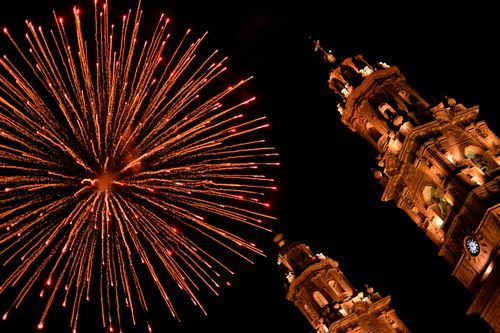 Free Fireworks illuminate Morelia Cathedral's baroque architecture on a festive night. Stock Photo