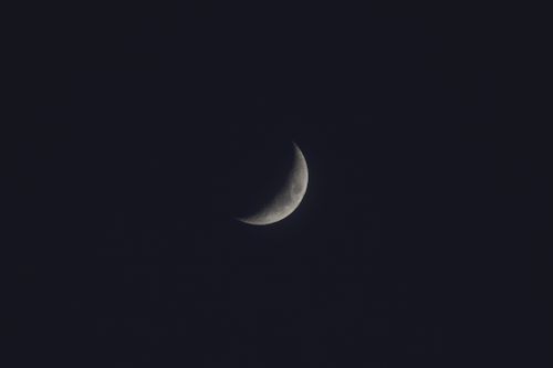 Free A serene crescent moon glows against a dark night sky, offering celestial beauty. Stock Photo