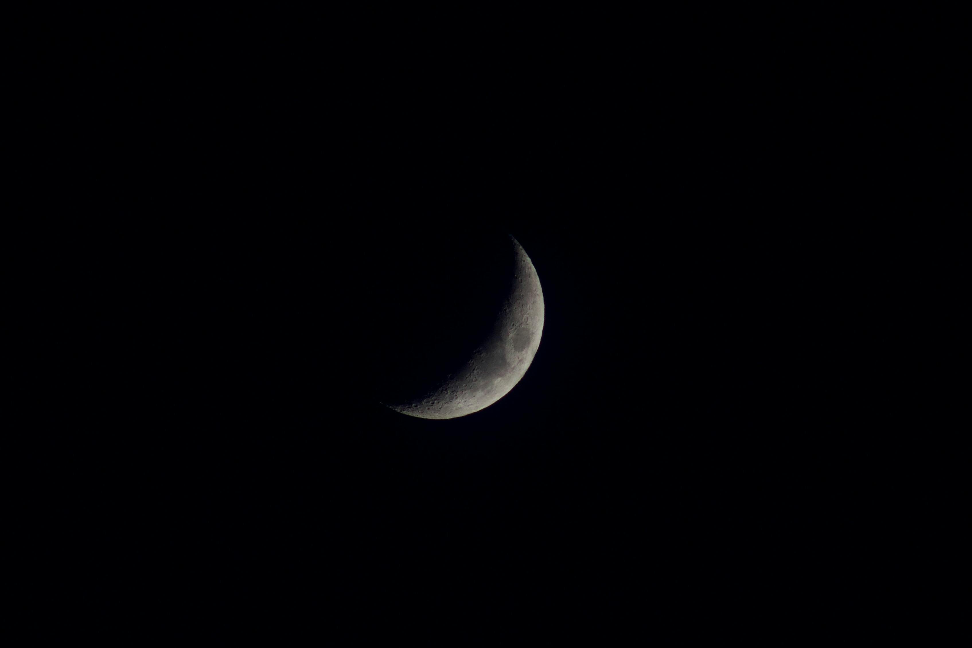 A crescent moon in the dark sky with a black background · Free Stock Photo