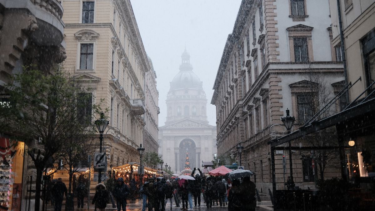 A snowy day in Budapest with Saint Stephen’s Basilica in the distance, capturing urban life.