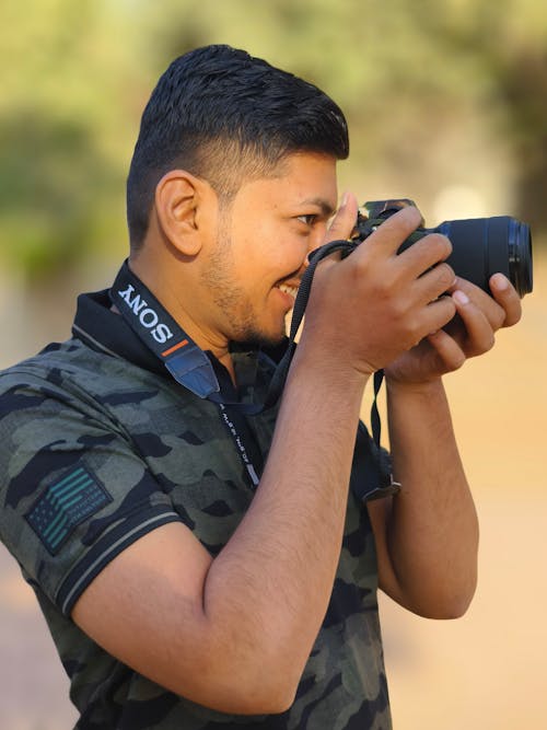 Portrait of Smiling Man Taking Pictures with Camera