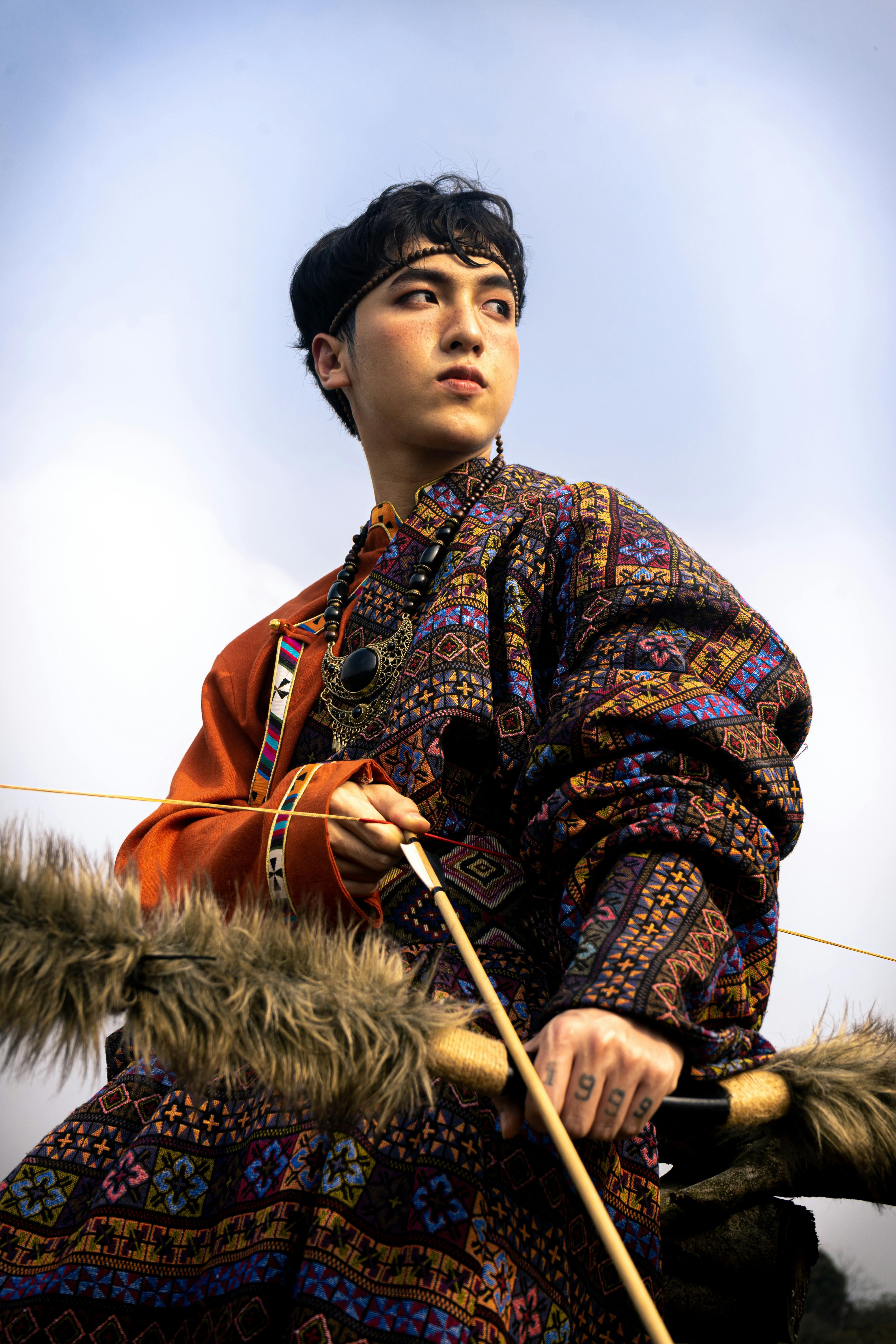 man in traditional costume holding bow and arrow