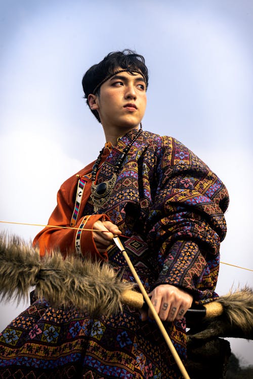 Man in Traditional Costume Holding Bow and Arrow