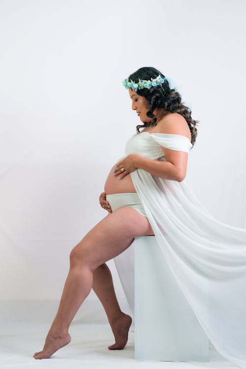 Pregnant Brunette Woman in White Dress