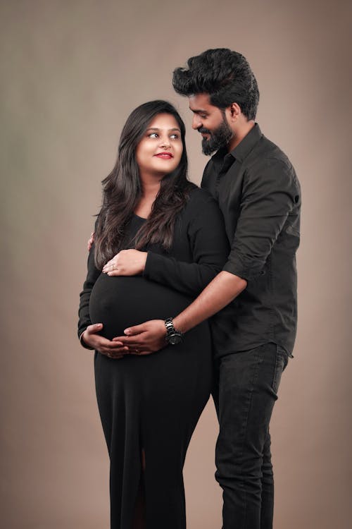 Man in Black Shirt and Pregnant Woman in Black Dress