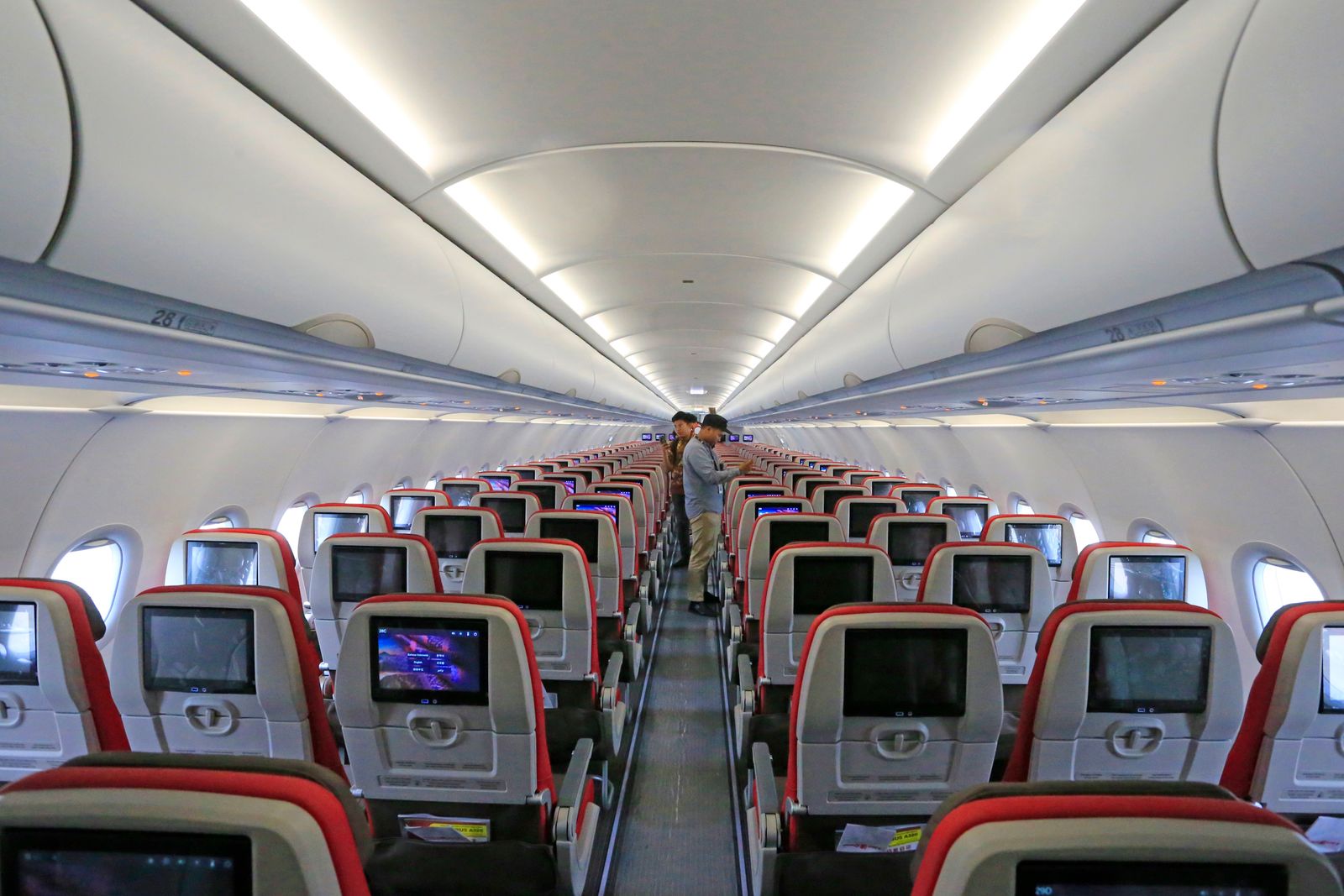 Overhead bins open inside an aircraft cabin