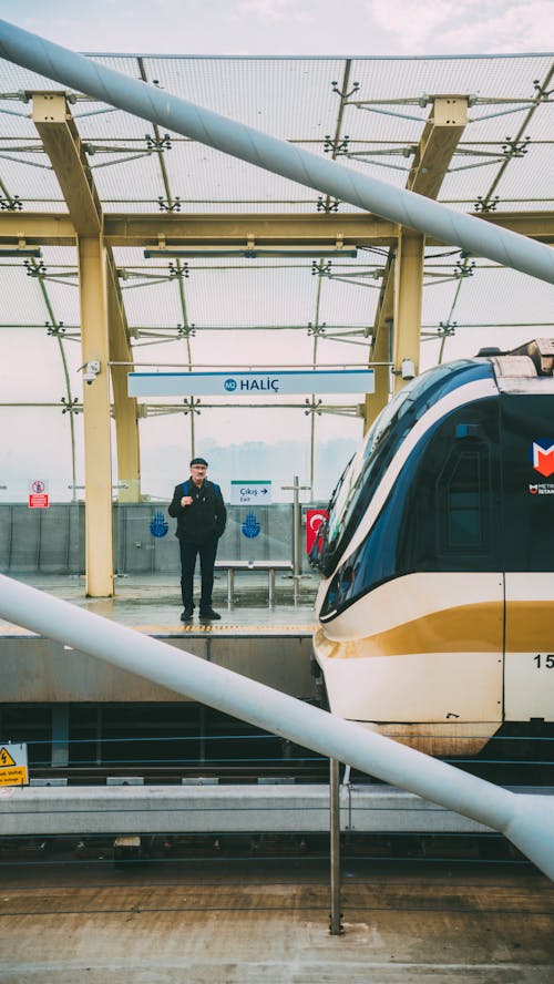 Foto profissional grátis de homem, plataforma da estação ferroviária, tiro vertical