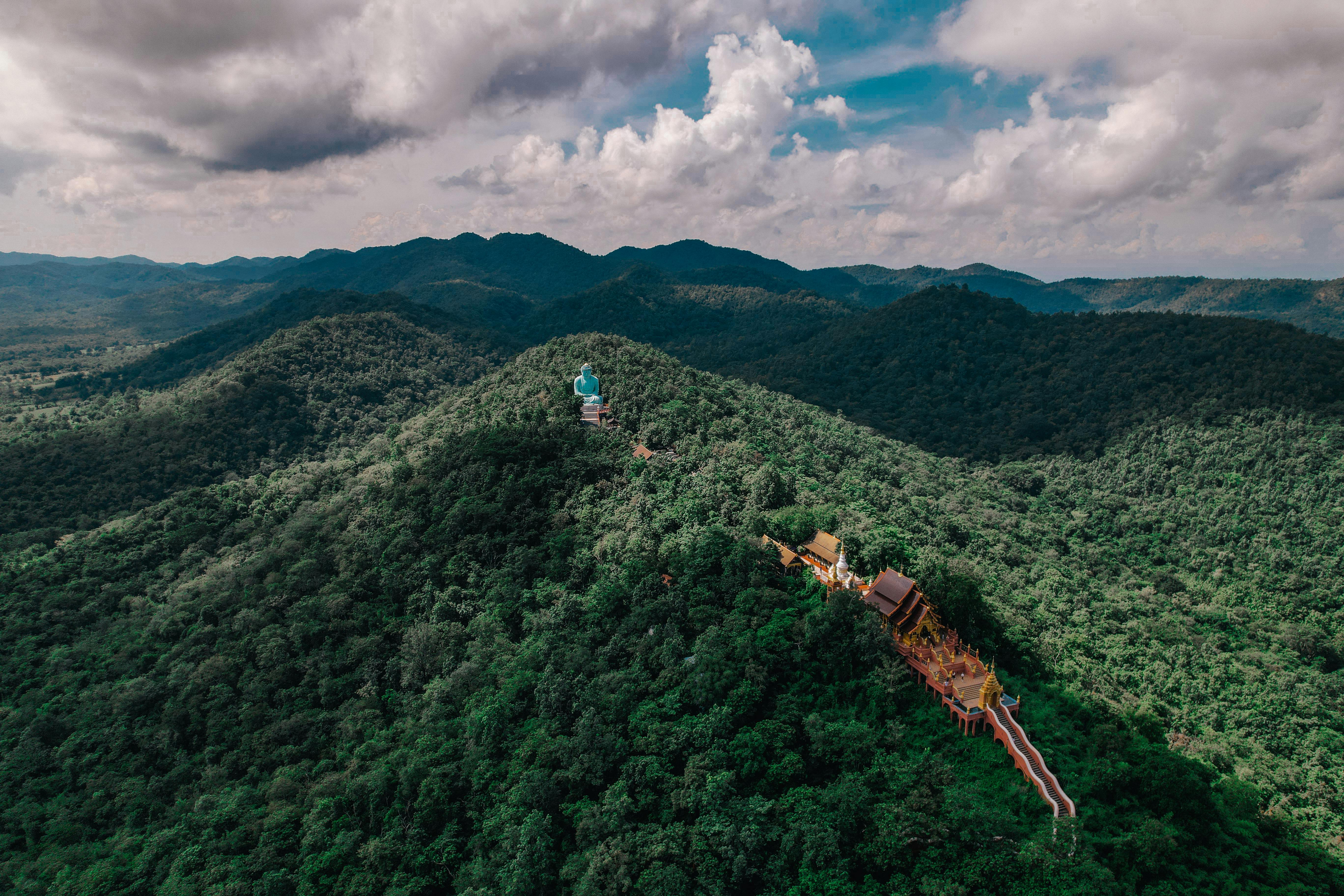 Aerial shot of Wat Phra That Doi Phrachan surrounded by lush forest in Tambon Pa Tan, Lampang, Thailand.