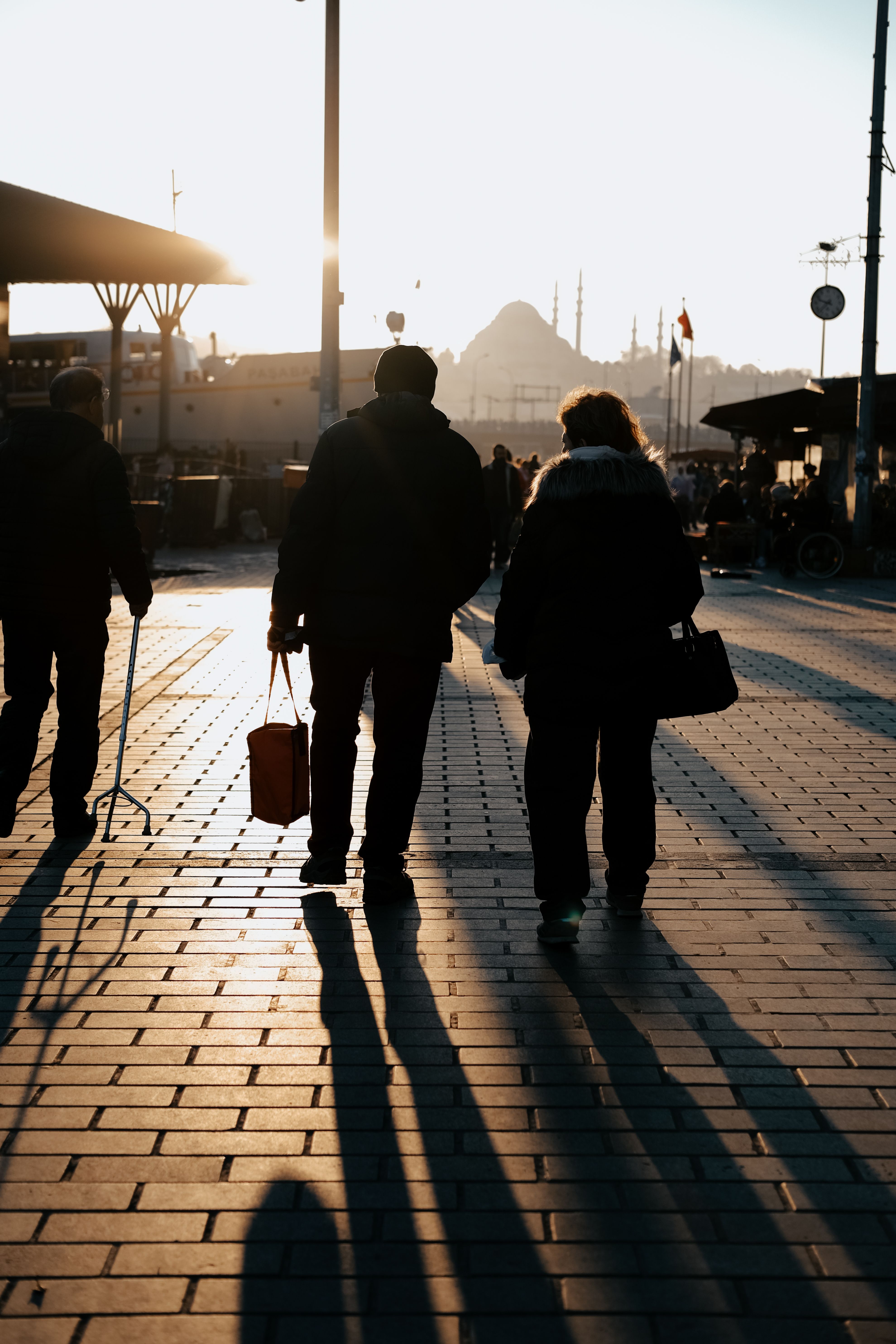 Silhouettes of People Walking down Street at Sunset · Free Stock Photo