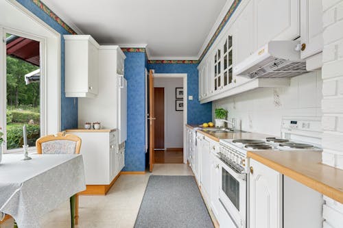 Kitchen Interior with White Cupboards and a Garden View Window