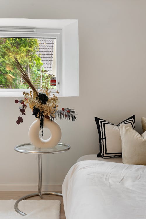 Decorative Twigs and Flowers on Bedside Table in Bedroom