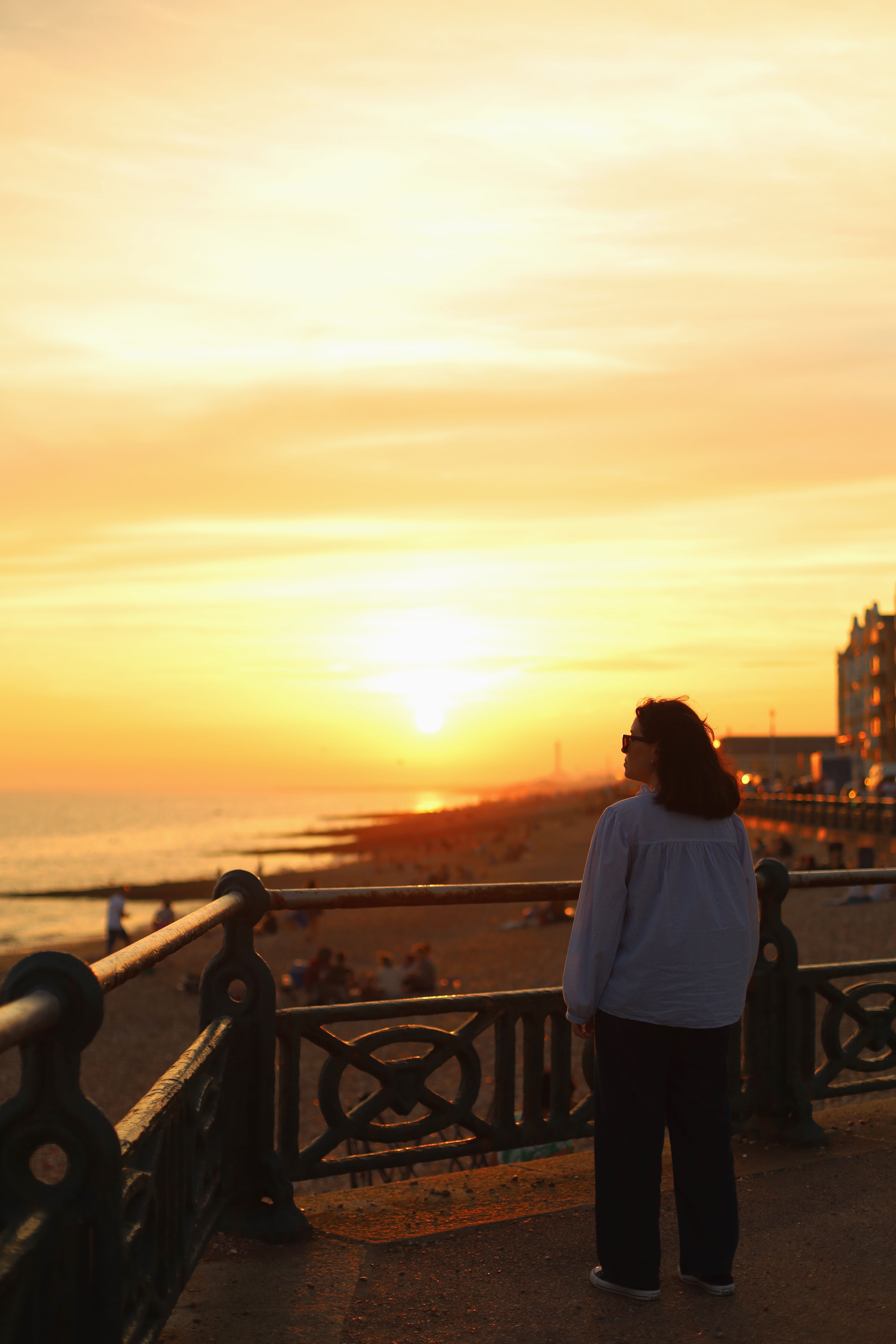 Woman on a Pier by the Beach During Sunset · Free Stock Photo
