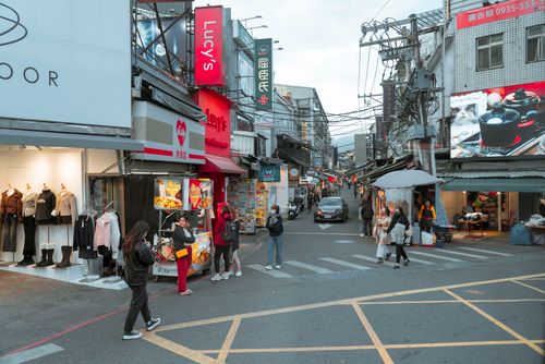 Free Lively city street in Taiwan featuring pedestrians, shops, and local signage in a vibrant urban setting. Stock Photo