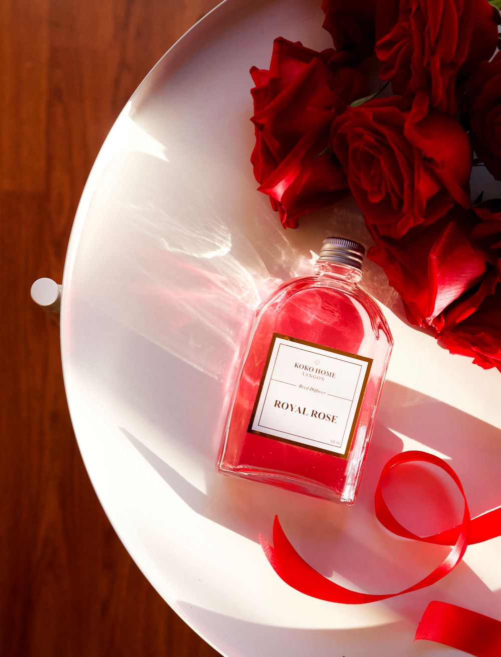 Elegant perfume bottle with roses in warm sunlight