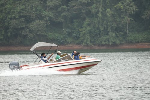People Riding a Motorboat on a Body of Water 