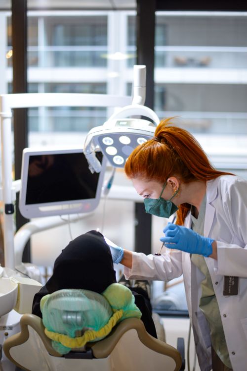 Free A dentist in a modern clinic performing a checkup on a patient, showcasing dental technology. Stock Photo