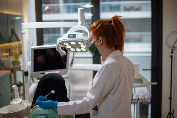 Dentista atendendo paciente em clínica moderna