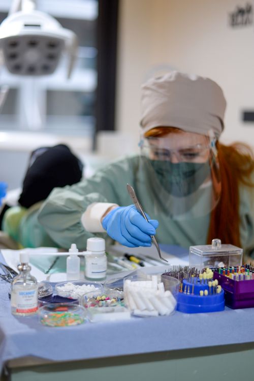Free A dentist preparing dental tools in an examination room, focused on hygiene and precision. Stock Photo