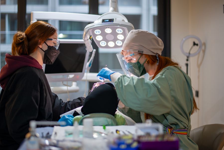 Dentist and assistant performing a dental procedure in a well-equipped clinic