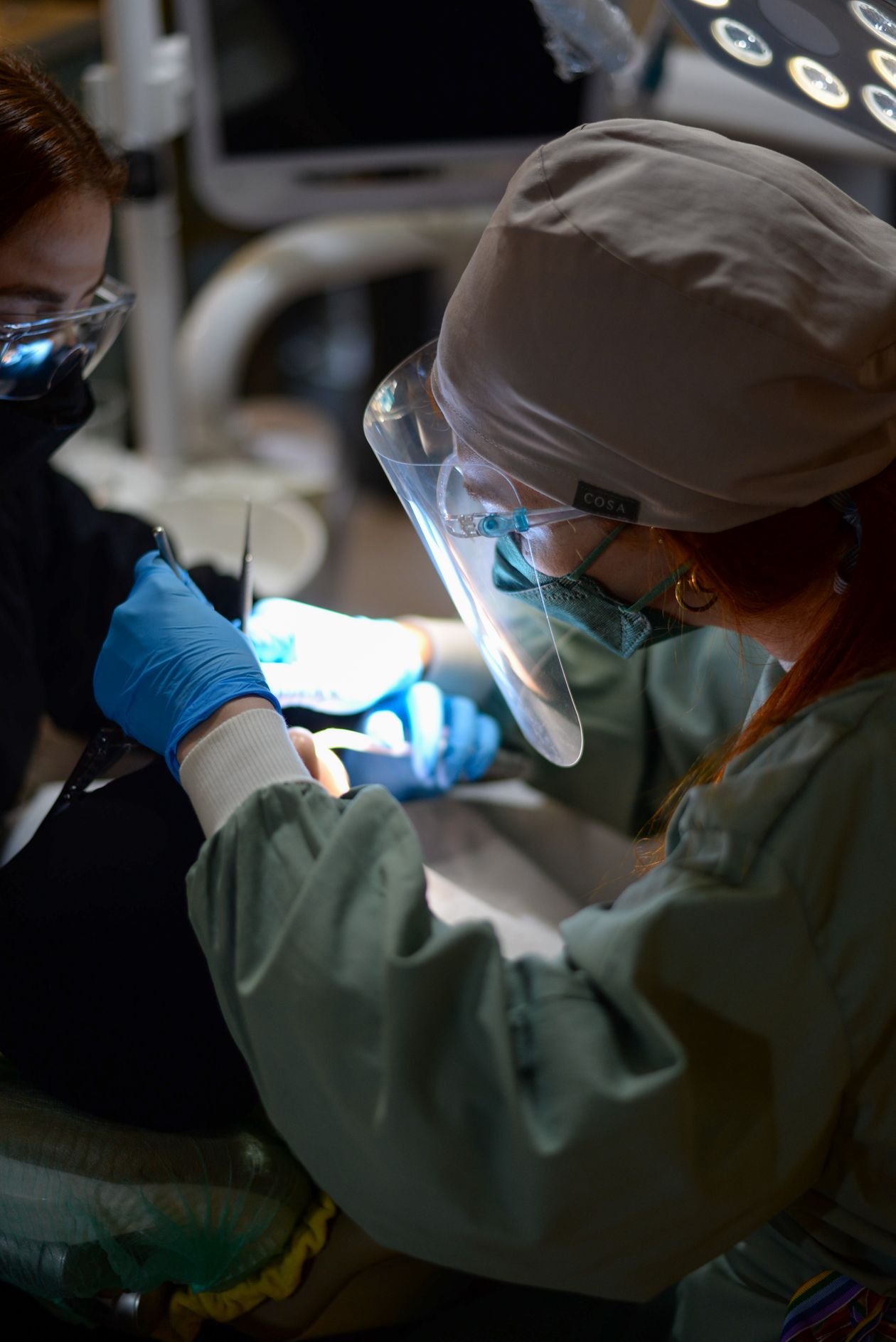 Odontoiatra in abbigliamento chirurgico durante una procedura di chirurgia orale