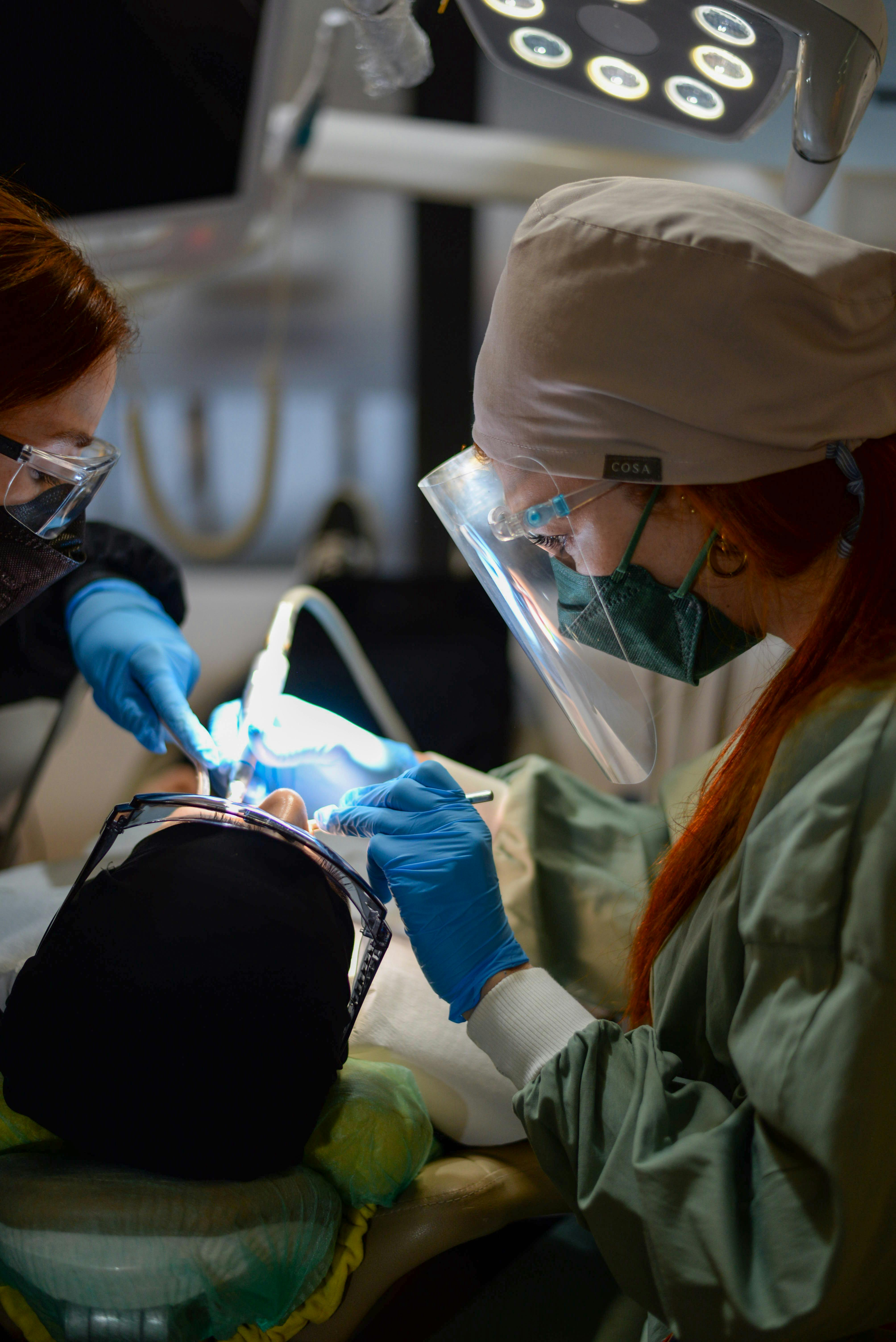 Dentists performing a clinical dental procedure with precision and care.