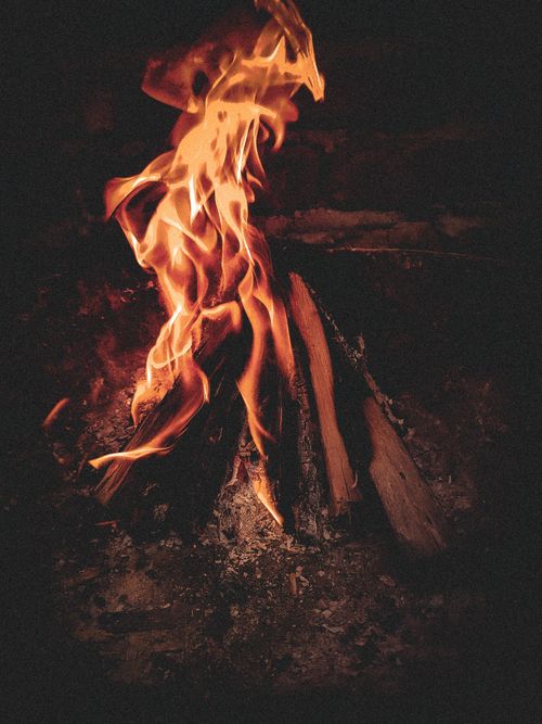 Free A warm campfire with vibrant flames burning against dark surroundings, perfect for cozy settings. Stock Photo
