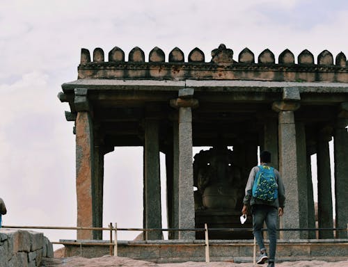 Back View of a Man Walking near the Sasivekalu Ganesha Temple in Hampi, India 