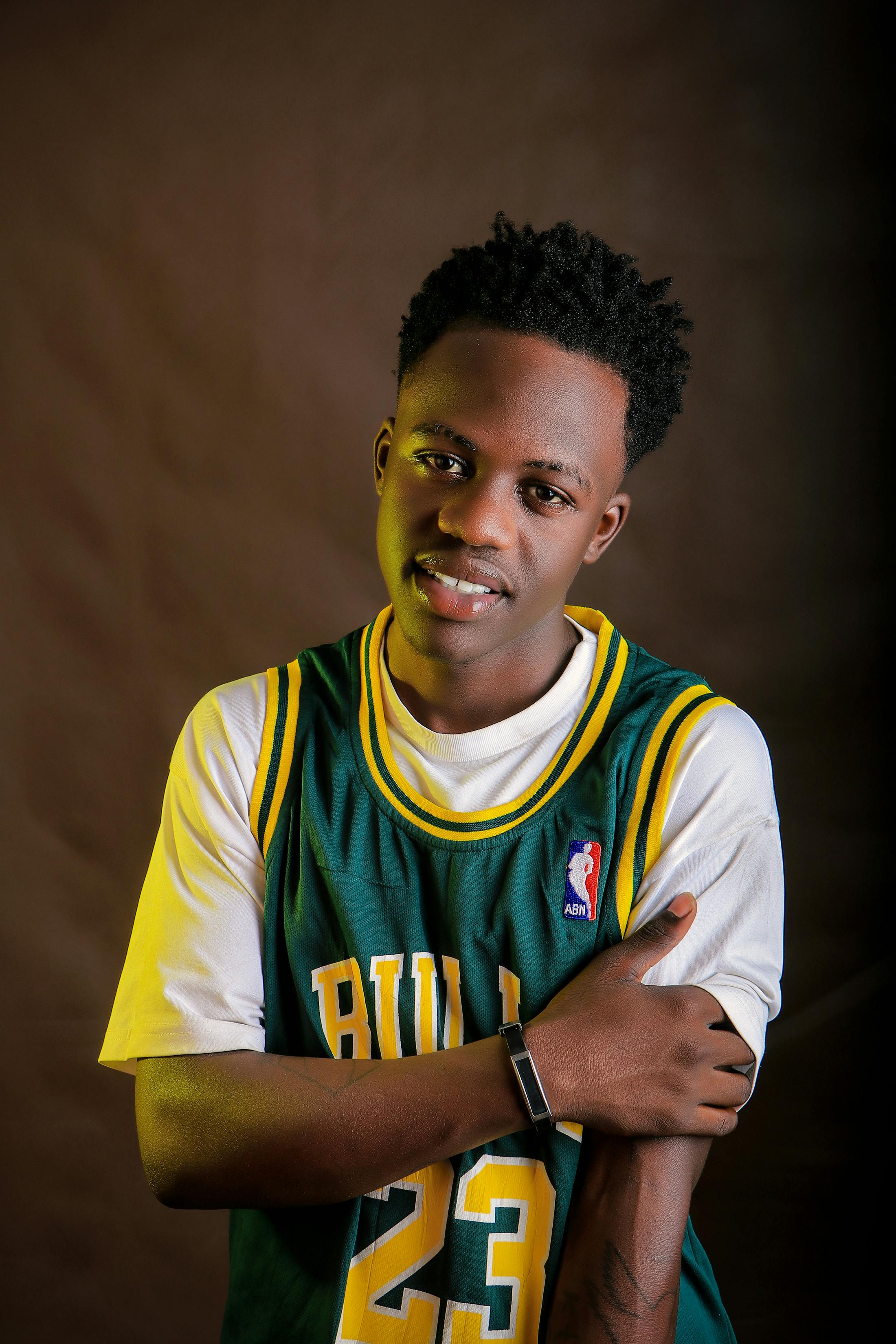 studio shot of a young man wearing a basketball jersey