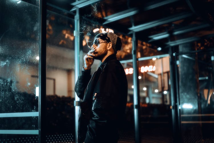 Man In Headscarf Smoking Cigarette At Night