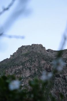 Serene view of a rugged rocky mountain at dusk, enveloped by a tranquil sky.