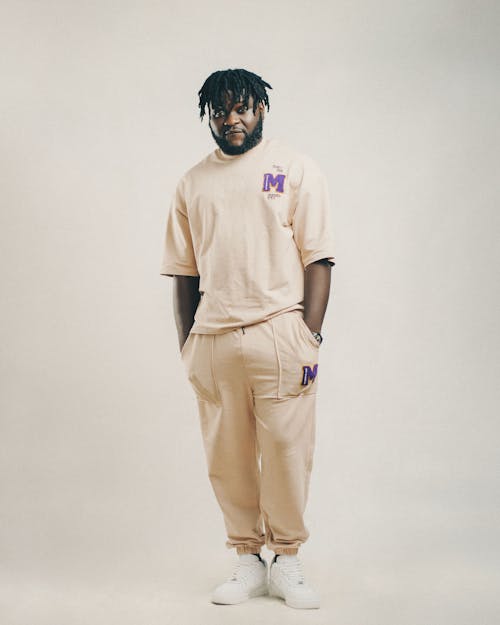 Man Posing in a Studio Wearing Beige T-Shirt and Pants