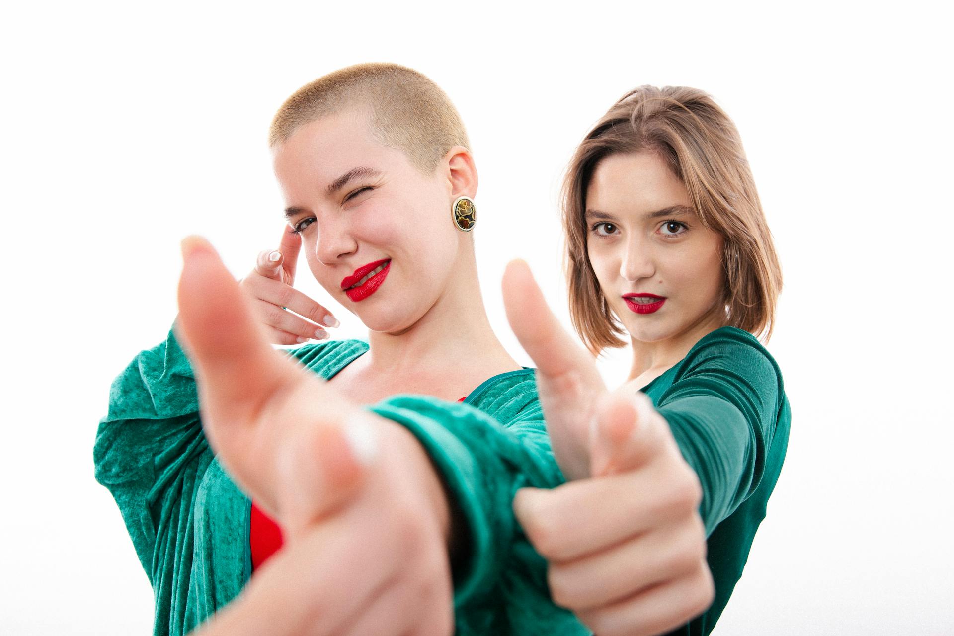 Women in Green Clothes Pointing at Camera
