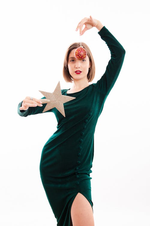 Woman in Green Dress Holding Christmas Ball and Star