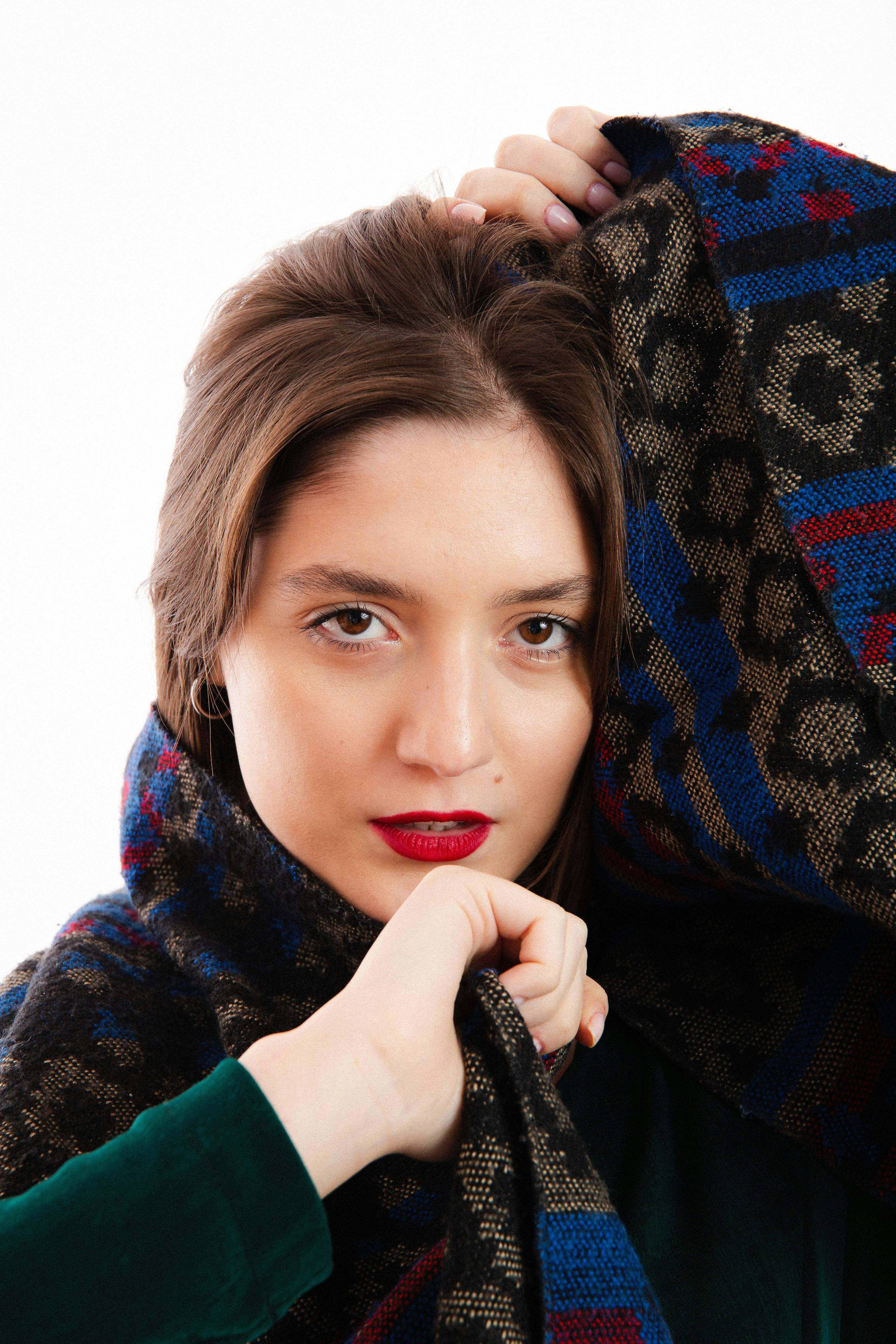 Vibrant studio shot of a woman wrapped in a colorful patterned scarf.
