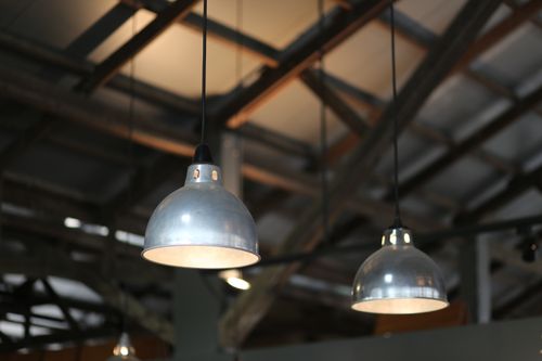 Free Close-up view of industrial hanging lamps in a warehouse setting. Stock Photo