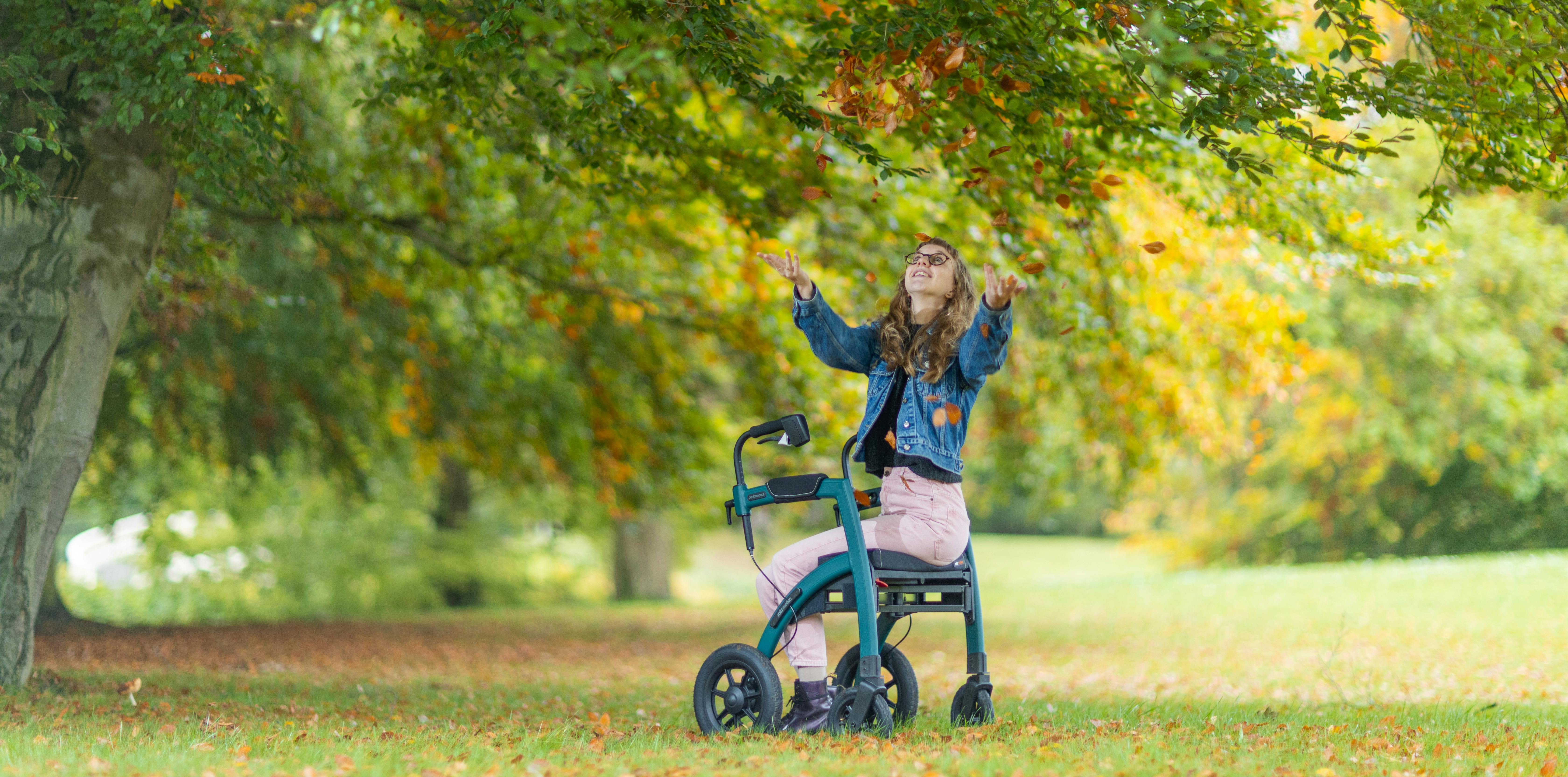 Woman with walker enjoying a sunny day under leafy trees in Amsterdam.