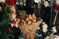 Close-up of an elegant floral arrangement with rustic wood centerpiece and assorted flowers.