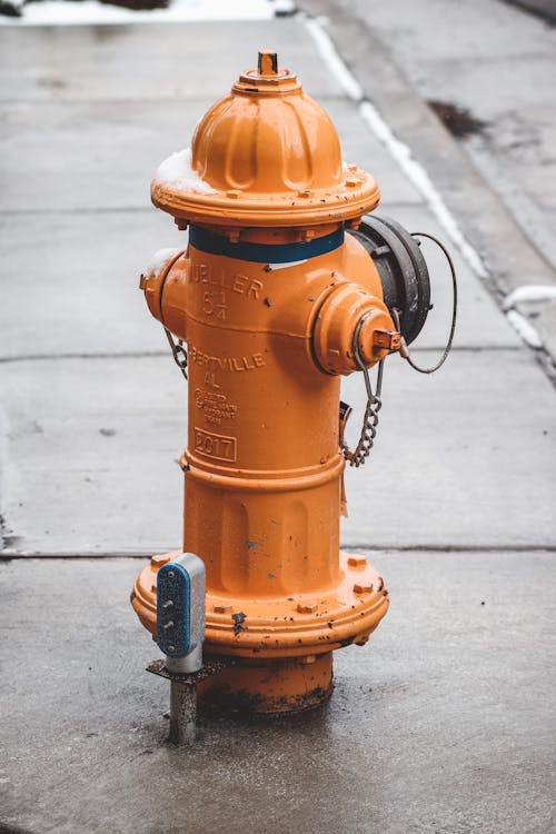 An Orange Fire Hydrant on Pavement