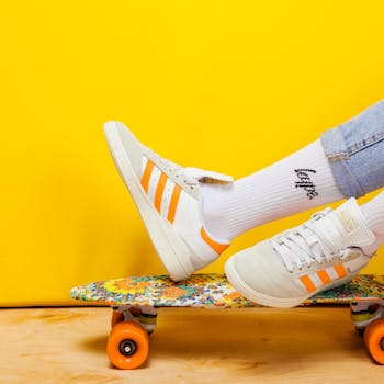 Colorful sneakers on a skateboard with a bright yellow background, showcasing vibrant and playful shoe fashion.