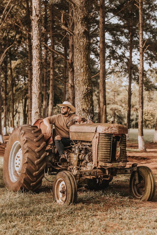 Man Sitting on Rusty Tractor