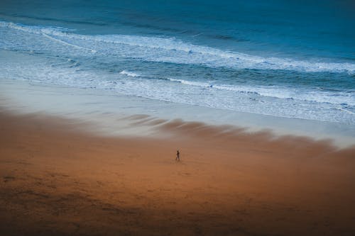 Man Walking on an Empty Beach 