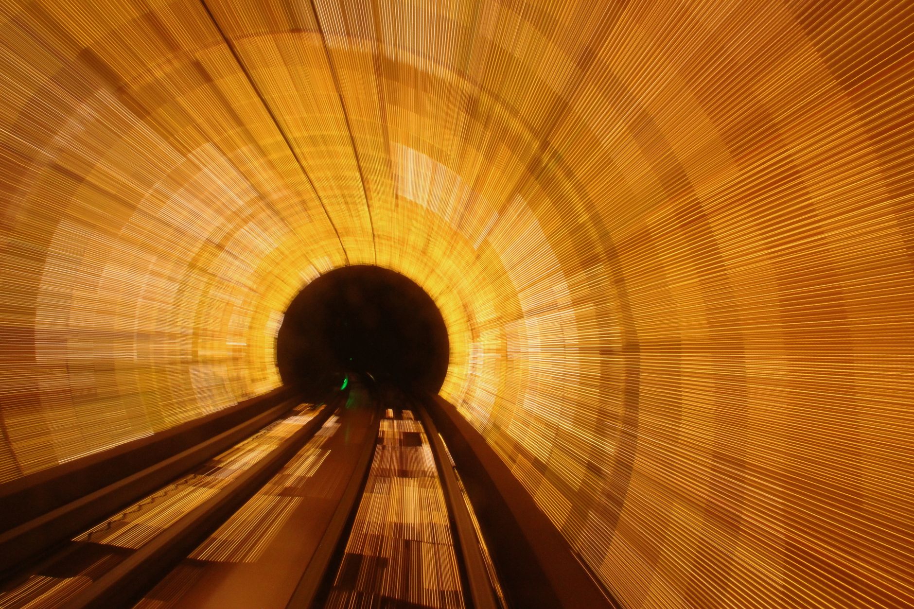 Long exposure shot capturing vibrant light patterns inside a tunnel, creating an abstract motion effect.