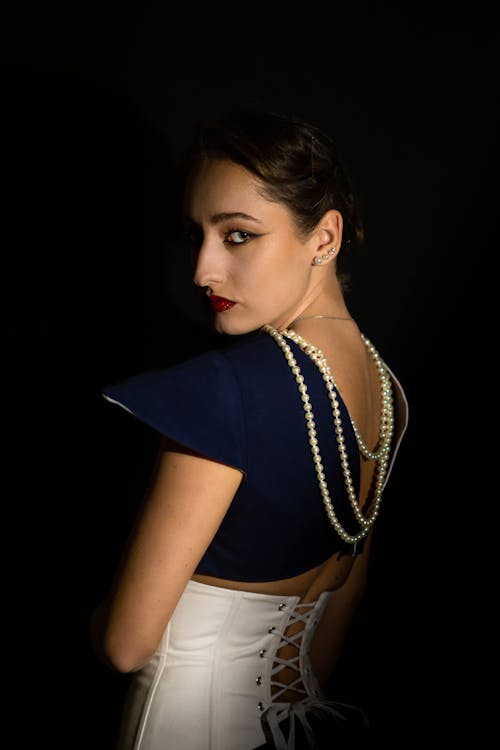 Studio Shot of an Elegant Brunette Wearing Pearls and a Red Lipstick 