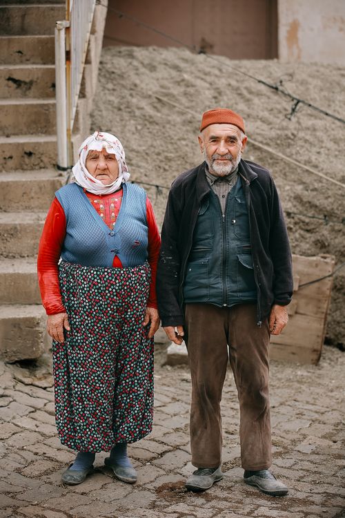 Free Portrait of a senior couple standing outside in Sivas, Türkiye. Traditional clothing and warm expressions. Stock Photo
